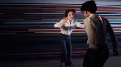 a man and a woman dancing together in front of a striped wall