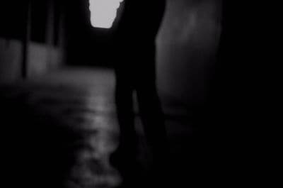 a black and white photo of a person in a dark room