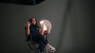 a woman sitting in a chair with her hands up
