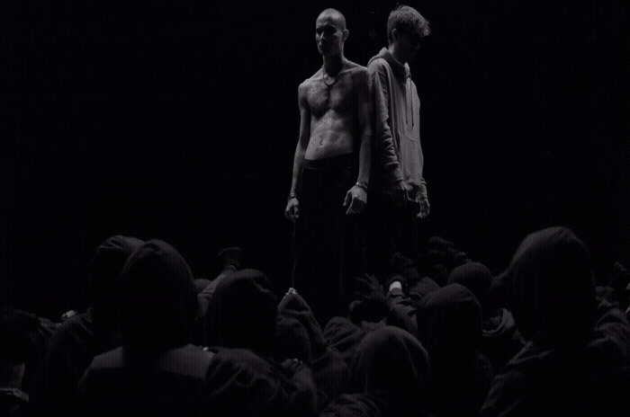 two men standing in front of a crowd of people