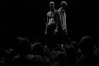 two men standing in front of a crowd of people