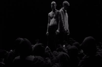 two men standing in front of a crowd of people