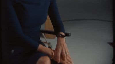 a woman in a blue dress sitting on a chair
