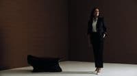 a woman standing in a room next to a bench