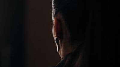 a man looking out of a window in the dark