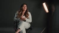a woman sitting in a chair in front of a light