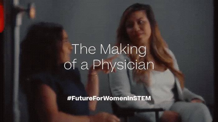 a woman sitting in a chair talking to another woman