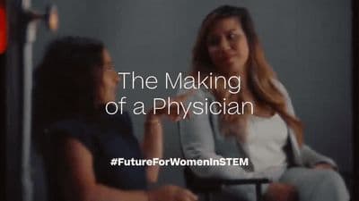 a woman sitting in a chair talking to another woman