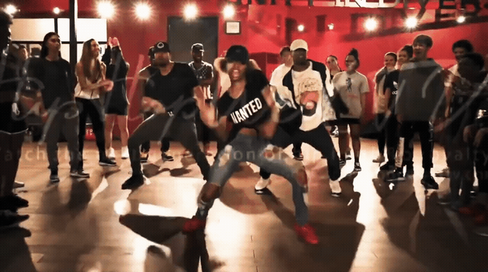 a group of people standing around each other on a dance floor