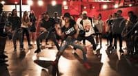 a group of people standing around each other on a dance floor