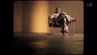 a woman sitting in a chair with her legs crossed