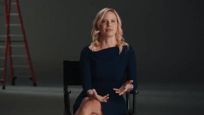 a woman in a black dress sitting in a chair