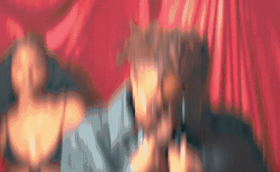 a blurry photo of two people in front of a red curtain