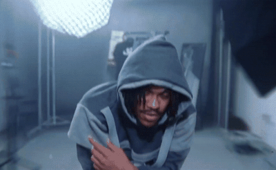 a man in a hooded sweatshirt standing in a bathroom