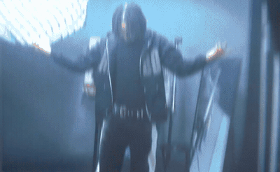 a man in a black outfit standing in a room