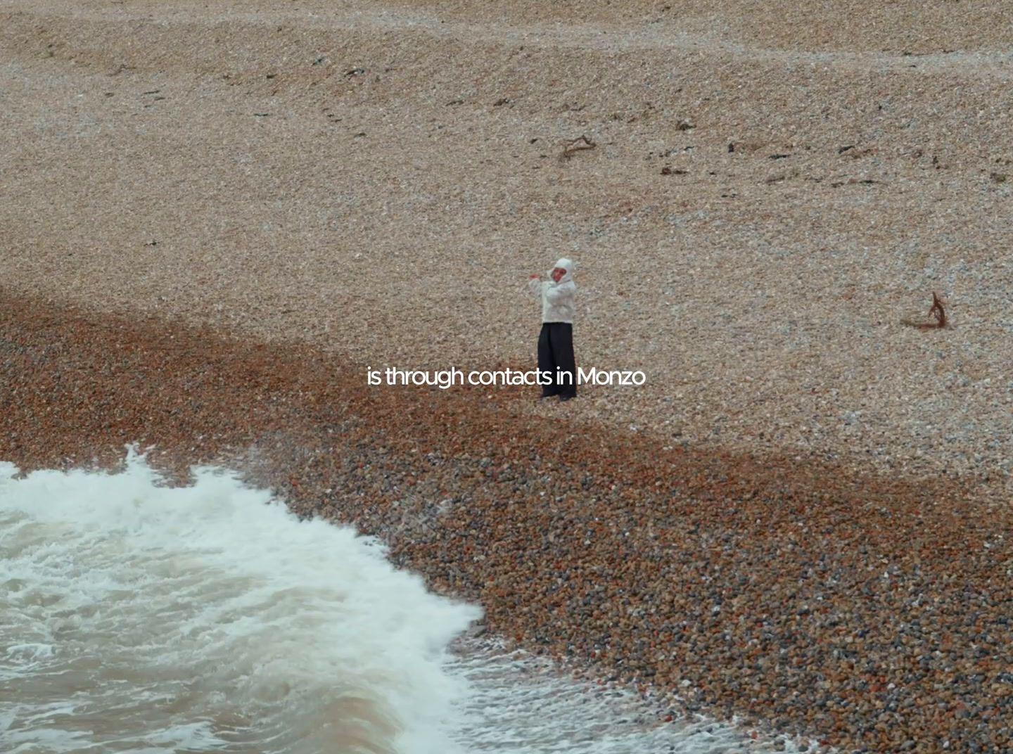 a man standing on top of a beach next to the ocean