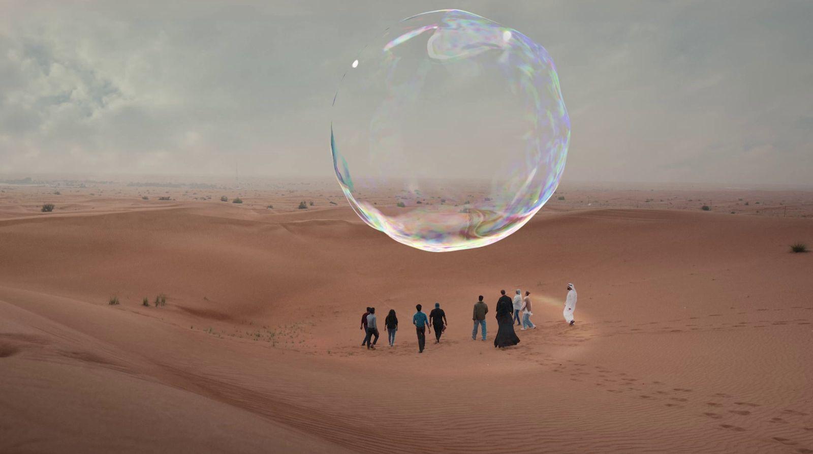 a group of people standing on top of a desert
