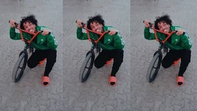 a man riding a bike on top of a sidewalk