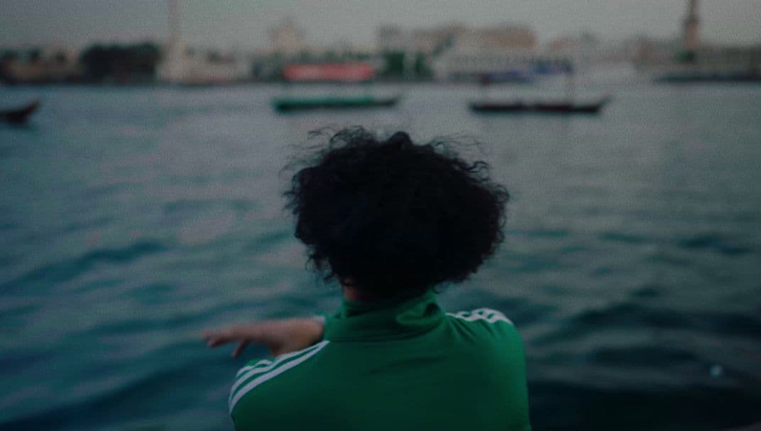 a woman pointing at boats in the water