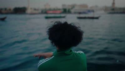a woman pointing at boats in the water