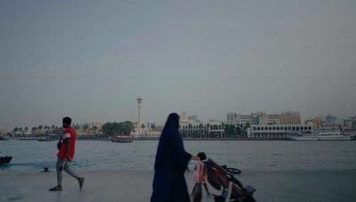 a man and a woman walking by a body of water