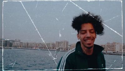 a man with curly hair and a green jacket