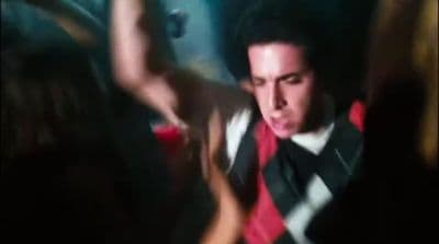 a man in a vest and tie making a face