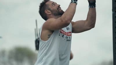 a man holding a barbell in his right hand