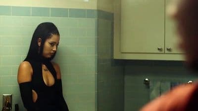 a woman in a black dress standing in a kitchen