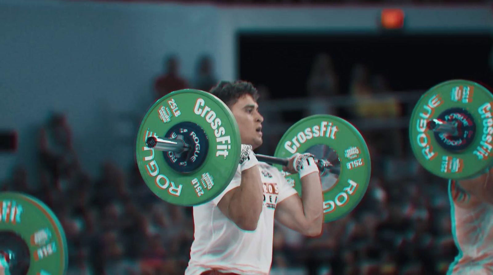 a man holding a barbell in front of a crowd