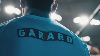 a man wearing a blue shirt with the word gard on it