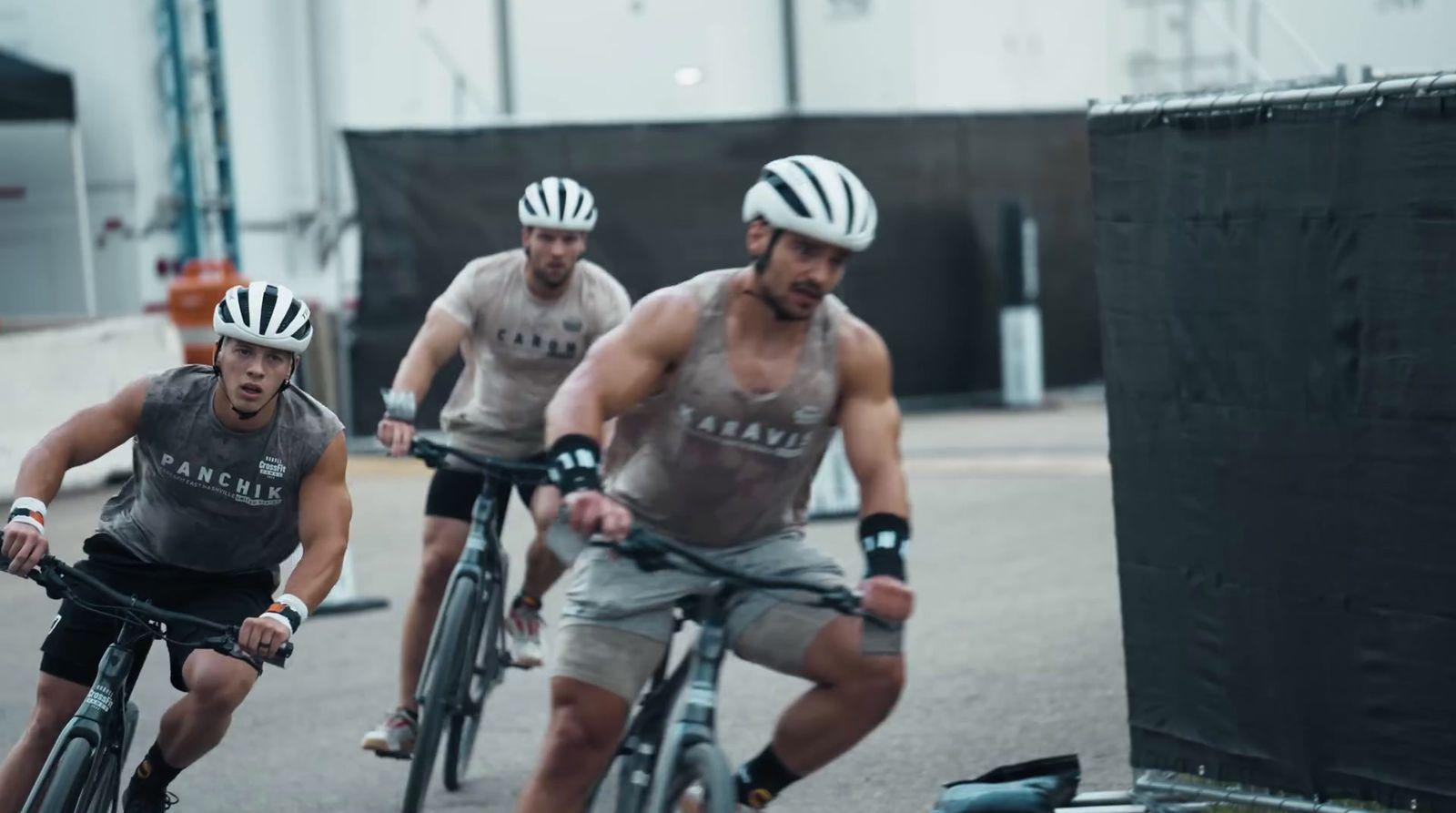 a group of men riding bikes down a street