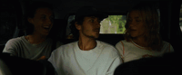 three people sitting in the back of a car
