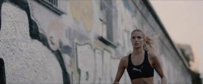 a woman in a black sports bra running down a street