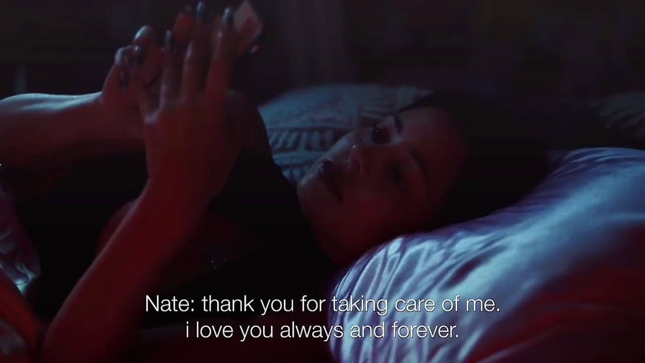a woman laying in bed with her hand up to her face