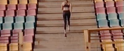 a woman is walking down a flight of stairs