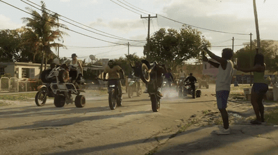 a group of people riding motorcycles down a dirt road