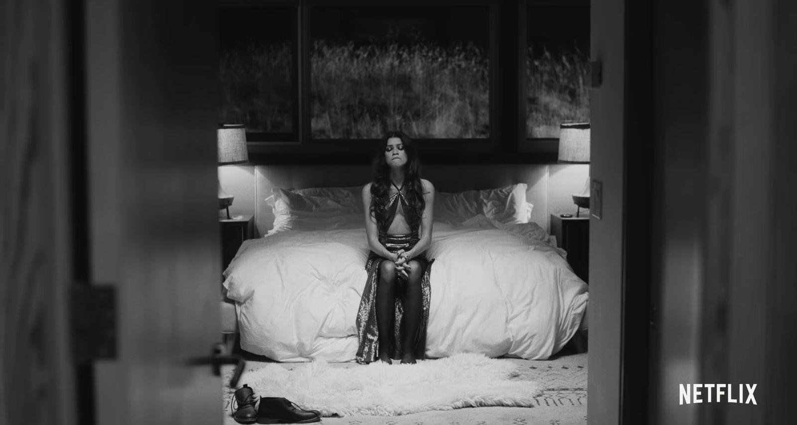 a woman sitting on a bed in a room