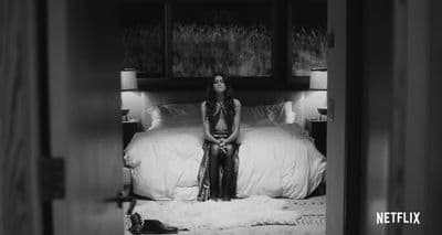 a woman sitting on a bed in a room