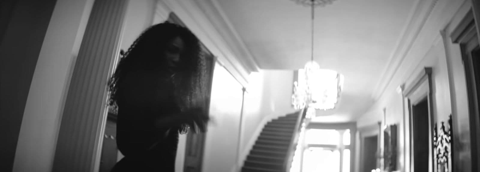 a woman standing in a hallway next to a staircase