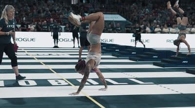 a man doing a handstand on a wrestling ring