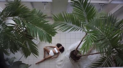 a woman in a white dress laying on a tiled floor
