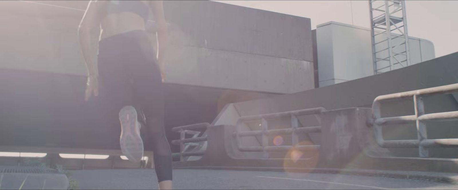 a woman in a black dress walking down a street