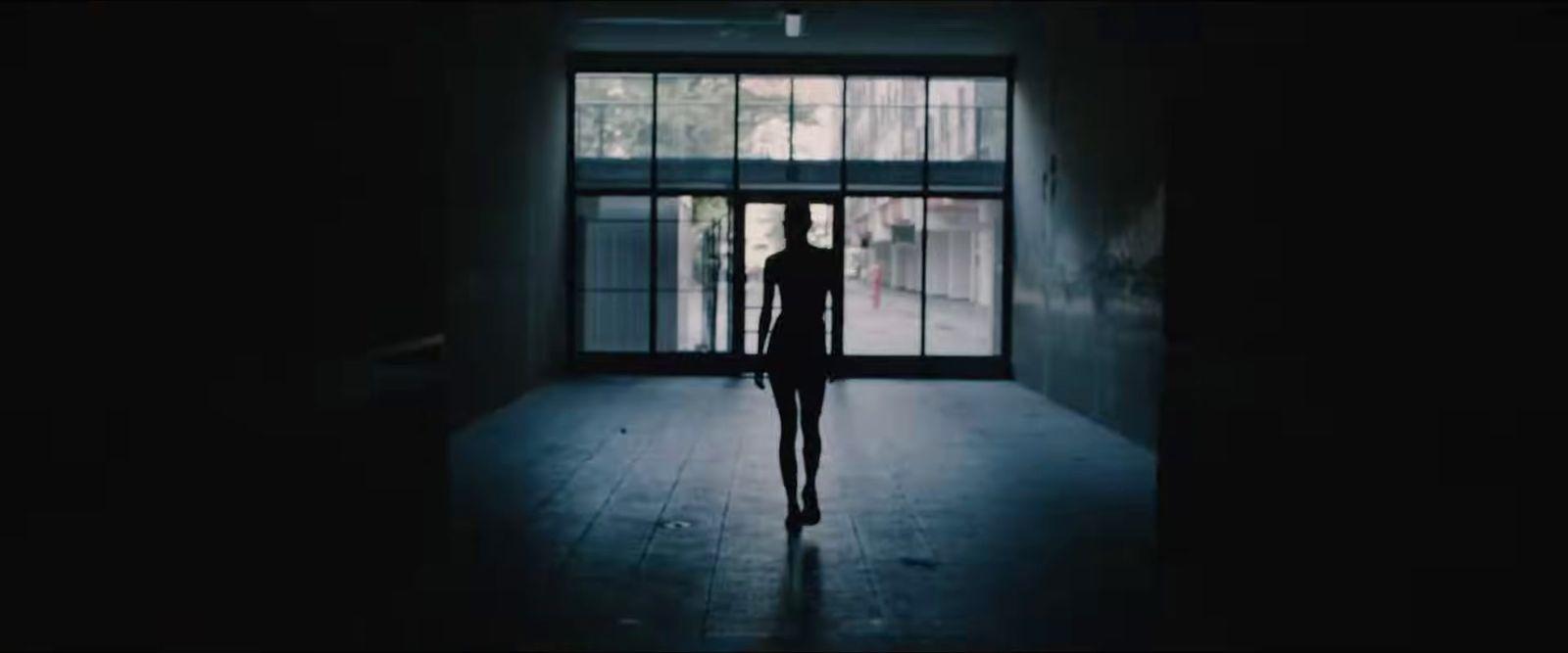 a person standing in front of a window in a dark room