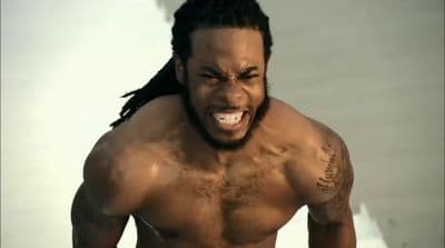 a shirtless man with dreadlocks on his head