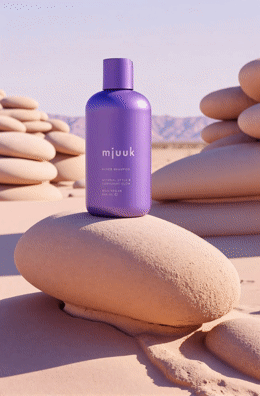 a bottle of musk sitting on top of a pile of rocks