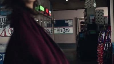 a woman in a red cape standing in a store