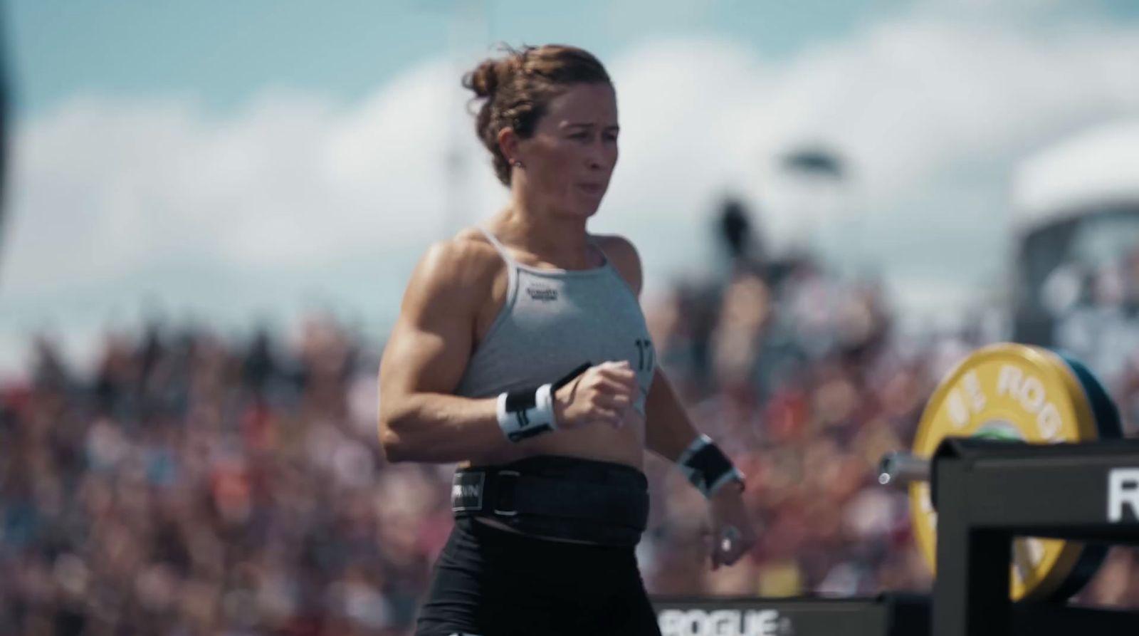 a woman running in front of a crowd