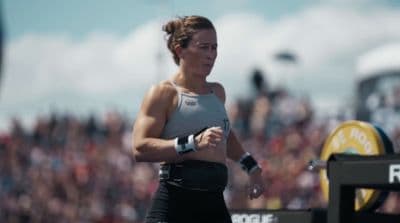 a woman running in front of a crowd