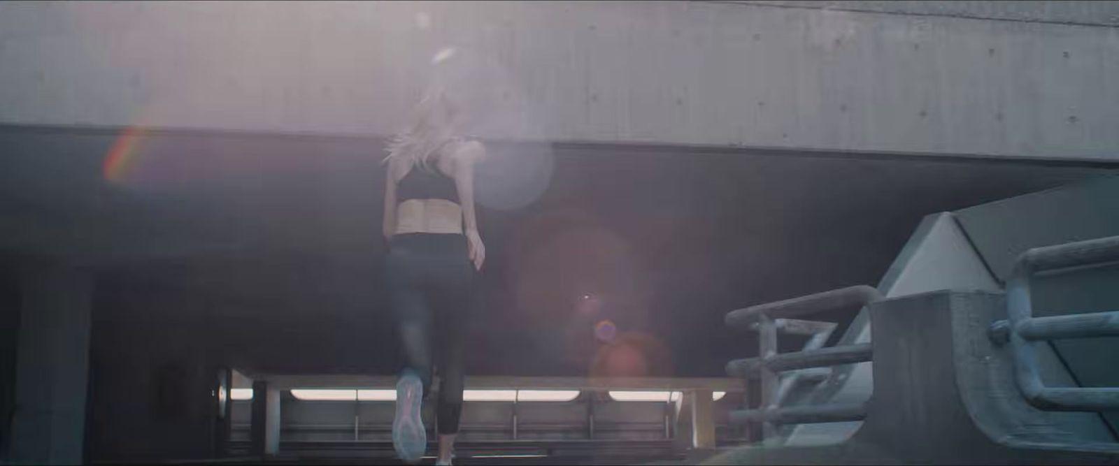 a woman is walking down a ramp in the sun